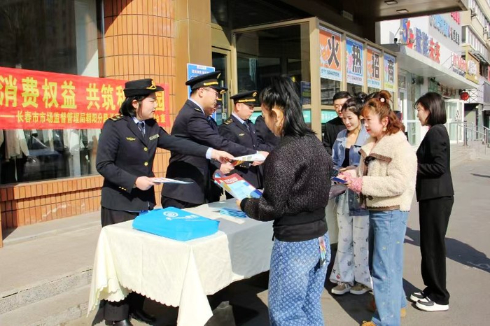 执法人员向商户和消费者发放宣传材料。
