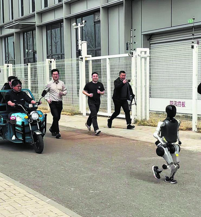 4月，为备战人形机器人马拉松，松延动力机器人公司工作人员在训练机器人。　企业供图