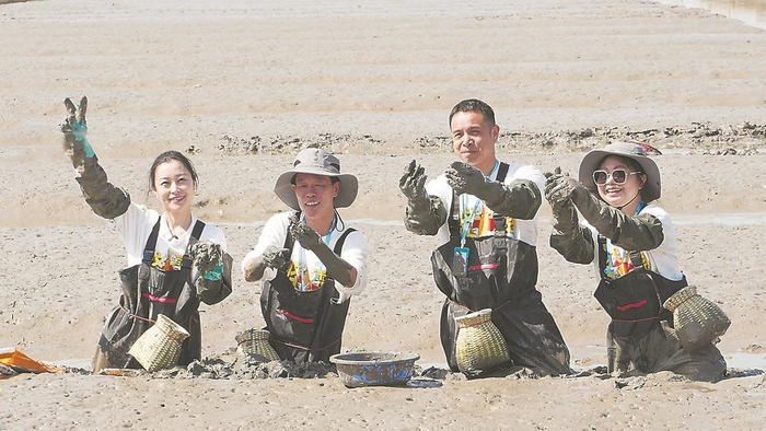 媒体记者和美食达人在黑泥滩涂体验挖蛏。杨成航 摄