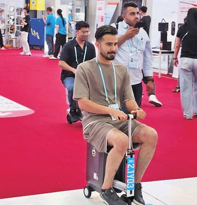 境外采购商在体验电动行李箱。 人民日报记者 韩春瑶摄