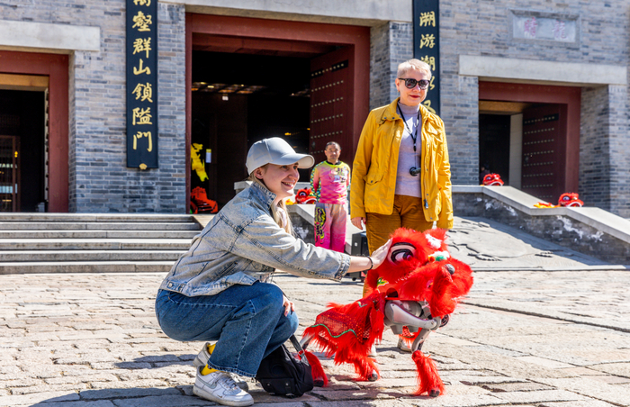 古北水镇的智能机器狗与游客热情互动。