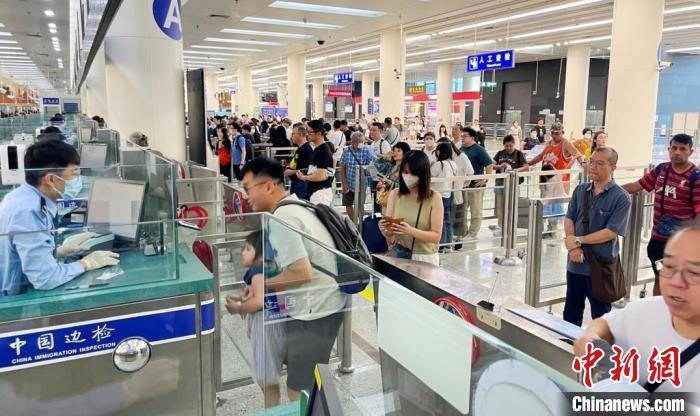 皇岗边检站民警开足通道为香港旅客办理入境查验手续。黄俊生摄