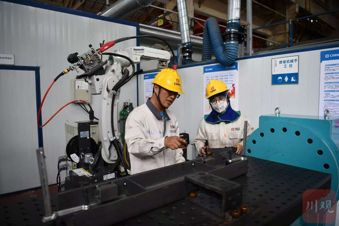 中国中车劳动模范、高级技师赵玉东（左）正在指导学员操作。