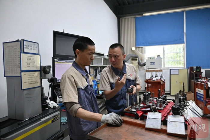 内江金鸿曲轴有限公司技术部刀具室主任、全国五一劳动奖章获得者赵小东（右）在工作中。