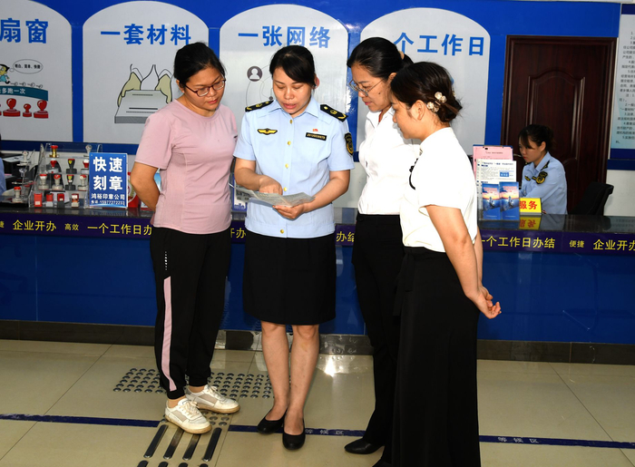 来宾市市场监管局服务窗口工作人员向经营主体宣传年报反诈骗有关知识