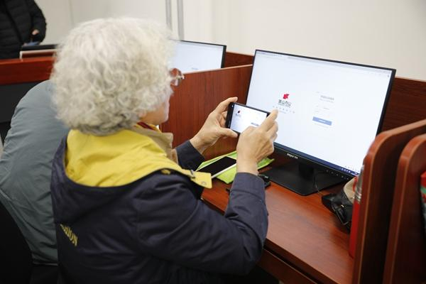 3月28日，济南老年人大学AI智能应用基础课堂上，一位老人在手机上使用AI工具。王丽歌/摄