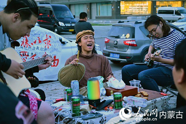 叶镇豪（左二）与满洲里当地的年轻人在街头高歌。人民网记者 寇雅楠摄