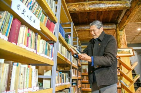 “书香爷爷”杨毅在整理图书。通江县委宣传部供图