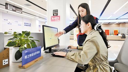     4月21日，在张家口市政务服务中心办事大厅，工作人员（站立者）在帮助民营企业办事人员办理业务。 本报记者 郭晓通摄