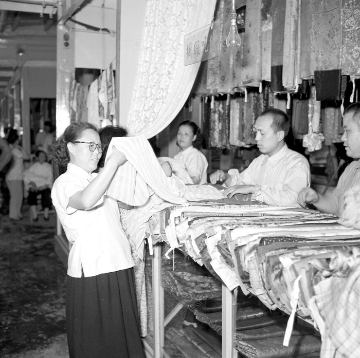 　　1956年，顾客在西单商场第四商场的公私合营旧货商店挑选绸缎。卓志摄