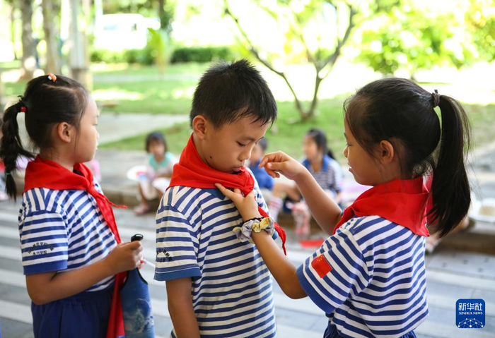 海南省三沙市永兴学校的少先队员们在“童心向祖国，我为祖国献首歌”活动中佩戴红领巾。（资料照片）新华社记者 樊雨晴 摄