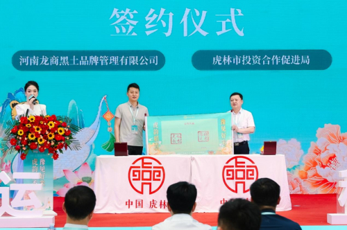 图:虎林市投资合作促进局副局长 王锟与河南龙商黑土品牌管理有限公司董事长 夏世宇
