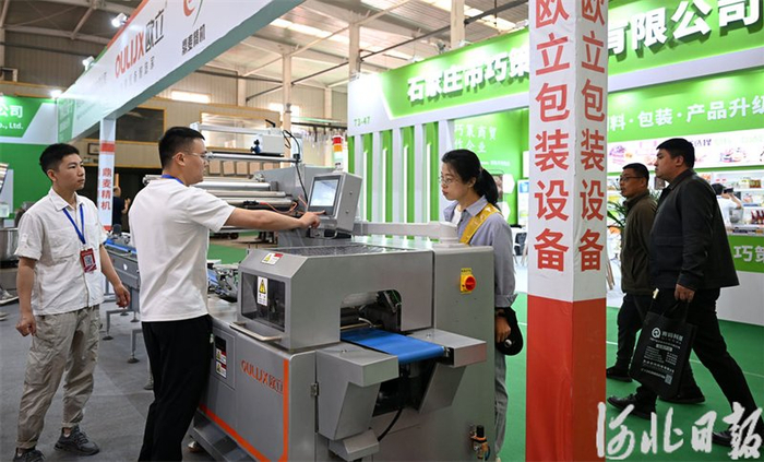 4月25日，在第三届河北（宁晋）食品产业博览会上，邢台一家食品包装设备公司工作人员在演示生产流程。