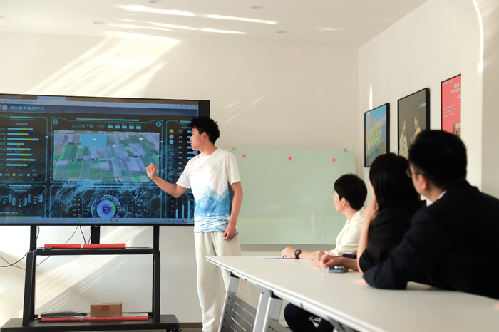 ▲科技小院学生向与会嘉宾演示养分智慧管控体系运行模式。刘长白｜摄