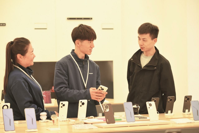 消费者在专卖店挑选手机。记者 邓建青 摄