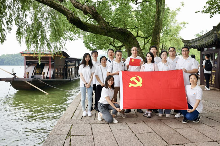 2024年7月1日，在浙江省嘉兴市南湖湖心岛，党员们与红船合影。新华社发（成杰 摄）