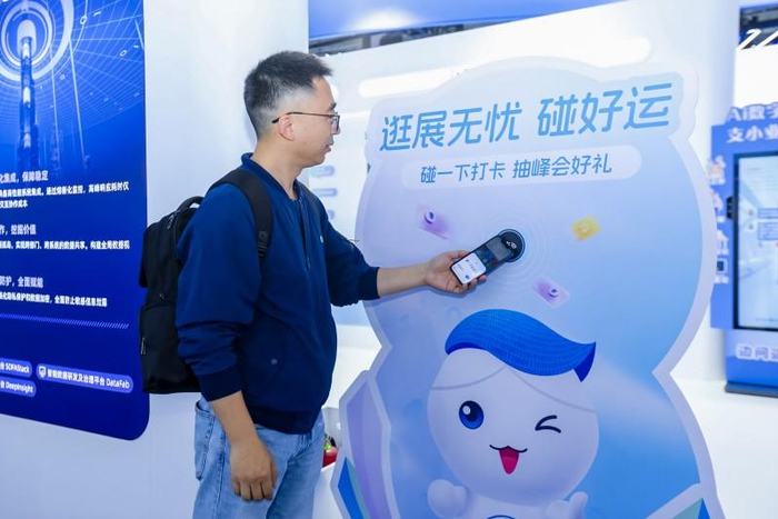 图说：参会者在数字中国建设峰会现场，用支付宝“碰一下”体验绿色低碳会展服务