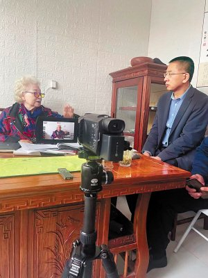 　　▲边清山采访抗日英烈王学尧的女儿王烈遗（左）。