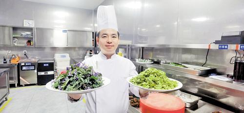     4月18日，悦湖酒店行政总厨孙志强展示刚采摘回来的榆钱儿和二月兰。 纵览新闻记者 张 岩摄