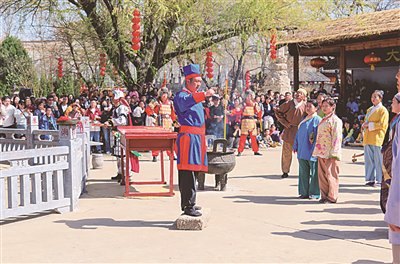 游客在洪洞大槐树景区观看《大槐树移民情景剧》表演。记者 康煜 摄 
