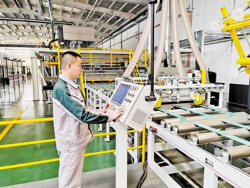     4月21日，在河北玻晶科技有限公司饰面板生产车间，工人正在操作生产设备。 本报记者 贾东亮摄