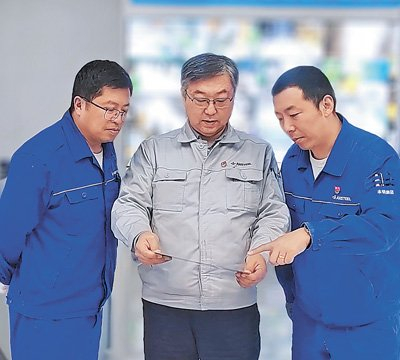 　　刘晓峰（中）和技术人员在研究汽车钢产品的质量稳定性。