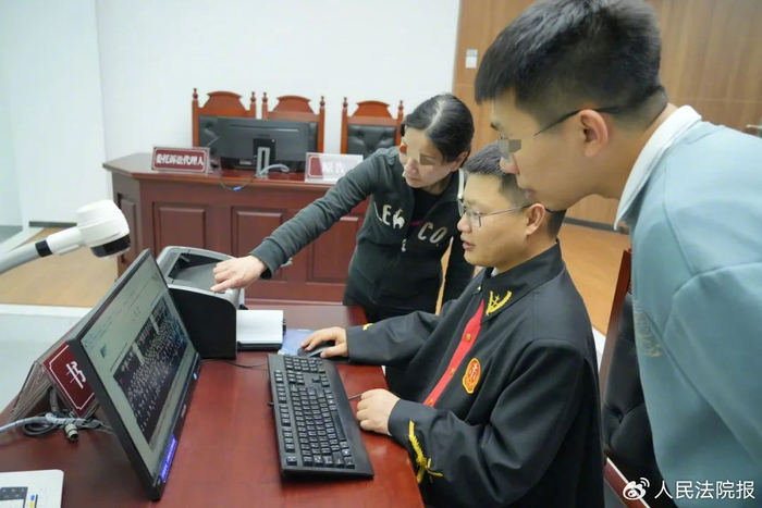 图为庭审中，廖大姐向重庆市璧山区人民法院法官张永（中）指出多年前公司员工合影中自己的位置。刘茂涵 摄