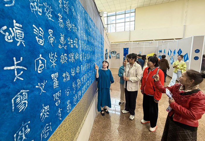 作者为市民讲解扎染作品的制作工艺。