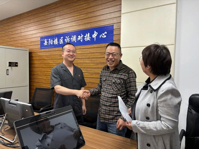 图为农民工代表握住湖南省岳阳市岳阳楼区人民法院法官刘界（左）的手，脸上写满感激，向他表达深深的谢意。杨子旋 摄