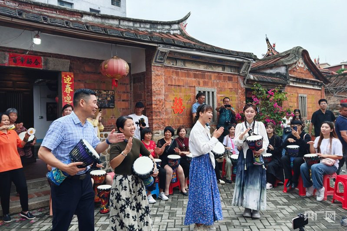 优质主播中国行走进田洋村采风，在古厝老宅前主播们与村民热情互动（央广网记者  邬眉  摄）