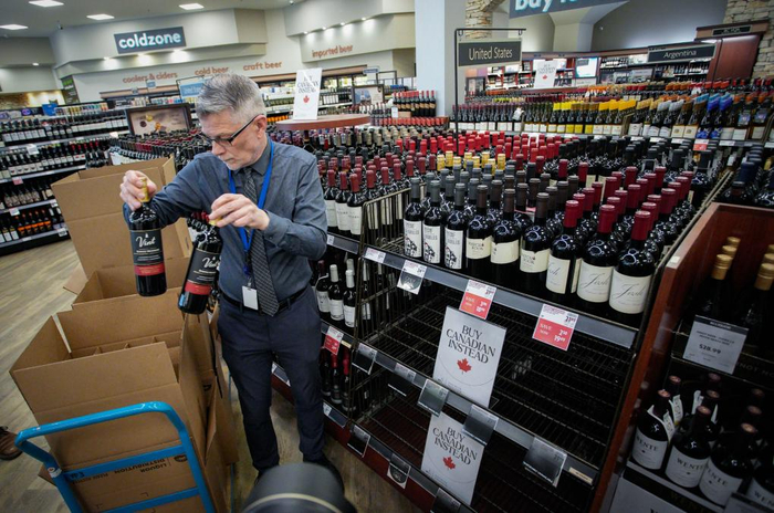 3月10日，在加拿大温哥华，一家不列颠哥伦比亚省酒类专卖店的店员从货架上撤下美国酒类产品。新华社发（梁森摄）