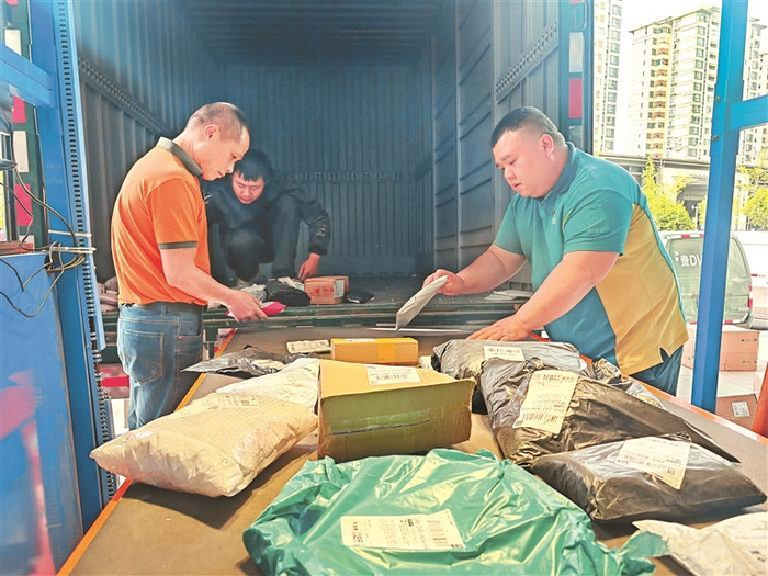 刘俊（右）整理准备投递的包裹。    韩静桦 摄