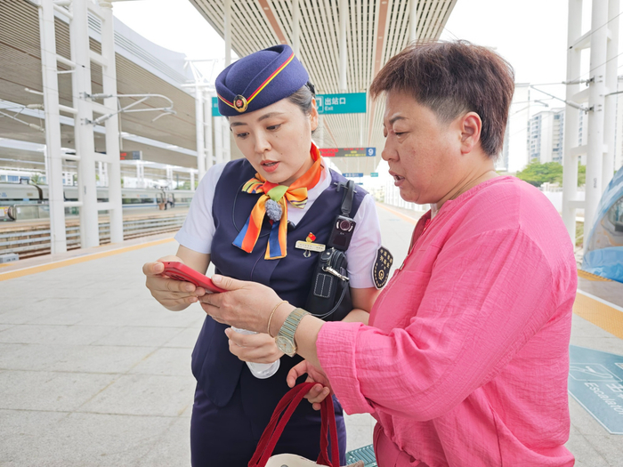 梁希影解答旅客问题（央广网记者  蔡文娟  摄）