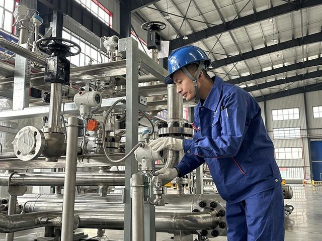 关涛正在检查氦气压缩机管路组压力表。新华社记者朱悦 摄