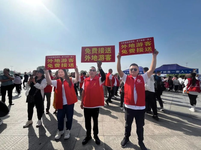荣昌志愿者手举“免费接送外地游客”的标示牌。图片来源：“荣昌微发布”微信公众号