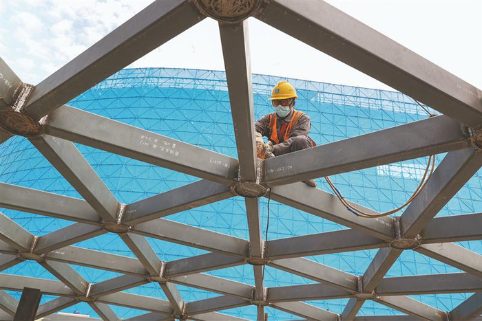 建设者在奥体中心施工现场打磨钢结构采光顶焊缝。（朱吉鹏 摄）