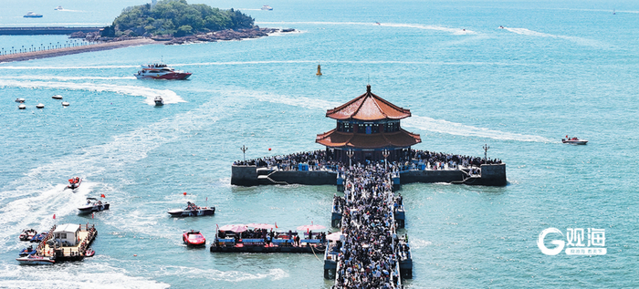 “五一”假期首日，青岛栈桥景区人潮涌动，海面上游船、快艇来回穿梭，勾勒出一幅活力四射的假日游图景。梁超 摄