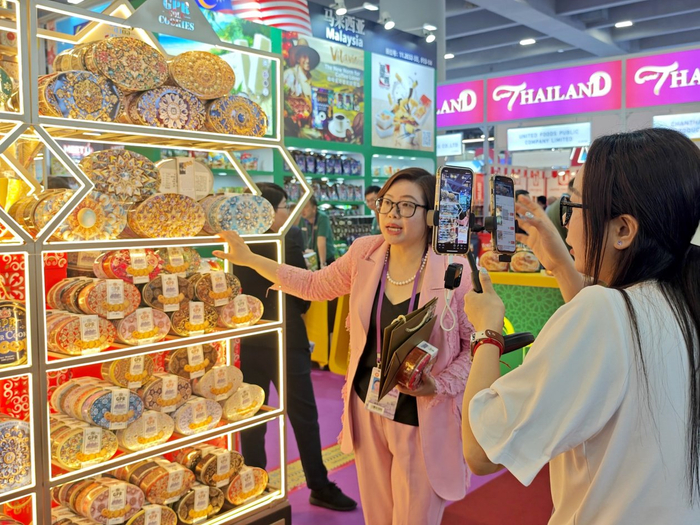 参展商直播卖马来西亚进口展的饼干。人民网 朴馨语摄