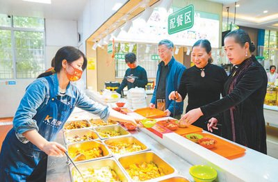 临川区县学岭社区一老一小幸福食堂，工作人员为老年人打菜。以上图片均为郭昊摄