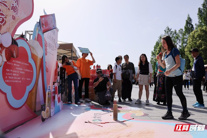 5月1日，在武陵源区吴家峪门票站广场，外国游客体验“山水奇境，潮玩五一”趣味活动。吴勇兵/摄