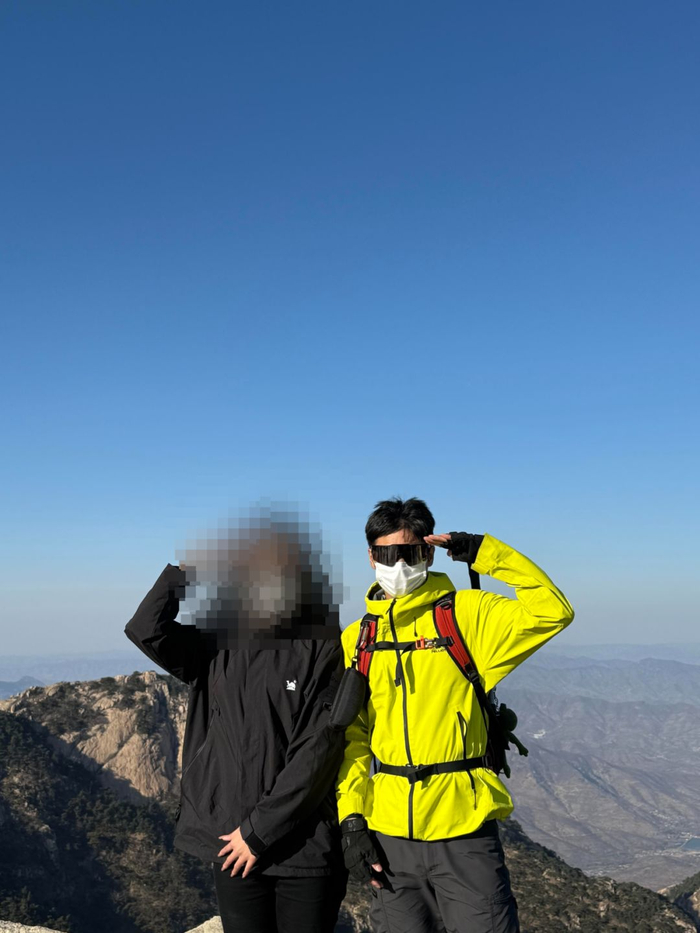 陪爬员陈无敌（右）与选择陪爬的游客在山顶的合影。受访者供图