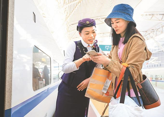 5月1日，在南京火车站，D5427次列车长在解答旅客问询。苏阳 摄