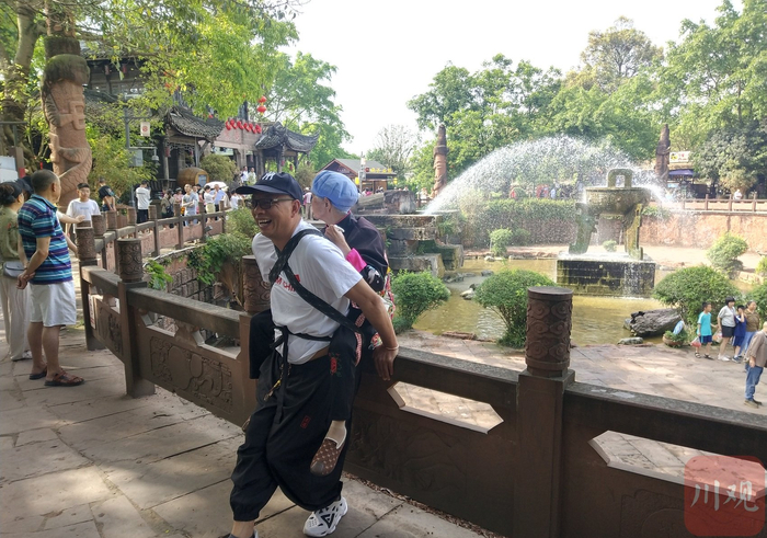 柴万斌背着妈妈旅游。