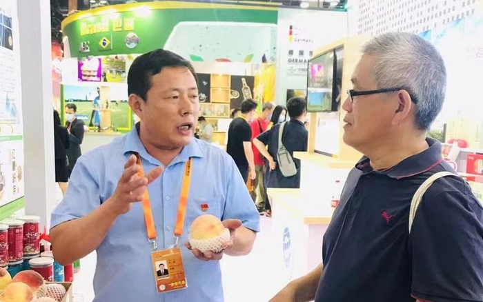 宫成和客户讲解大桃生产过程。受访者供图