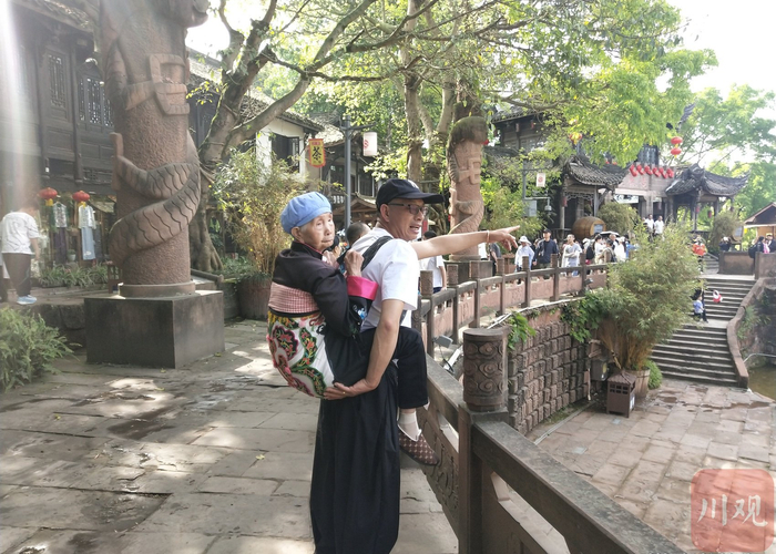 柴万斌背着妈妈旅游。