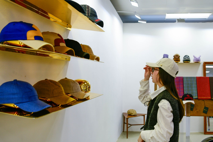 买手正在试戴帽子。劳动报记者颜筱依 摄影