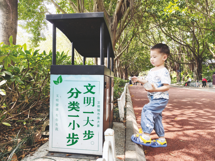     ▲南湖公园里，小朋友将垃圾投进垃圾桶。