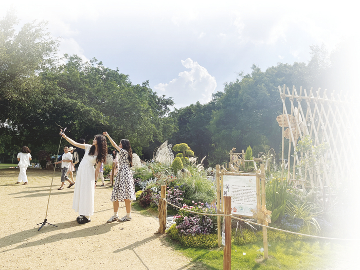     ▼游客在南湖公园花境大赛作品前拍照留念。    本报记者 廖欣 摄