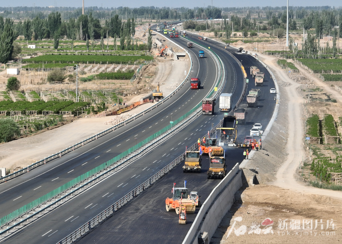 G30连霍高速改扩建哈密至吐峪沟段第10标段施工人员在摊铺沥青。曹鹏摄