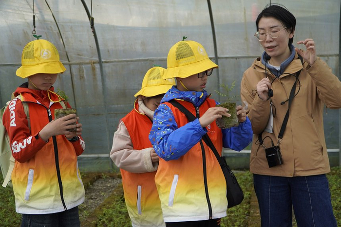 周李萍为小学生们讲述崖柏的“重生”故事。受访者供图